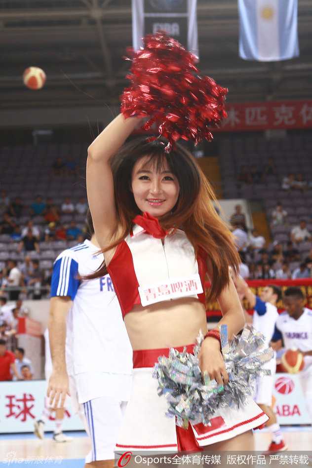 镜头拉近，这位领舞的拉拉队员眼神专注而明亮，手中的花球仿佛被注入了魔力，随着她矫健的身姿上下翻飞，在赛场灯光下留下一道道炫目的残影。