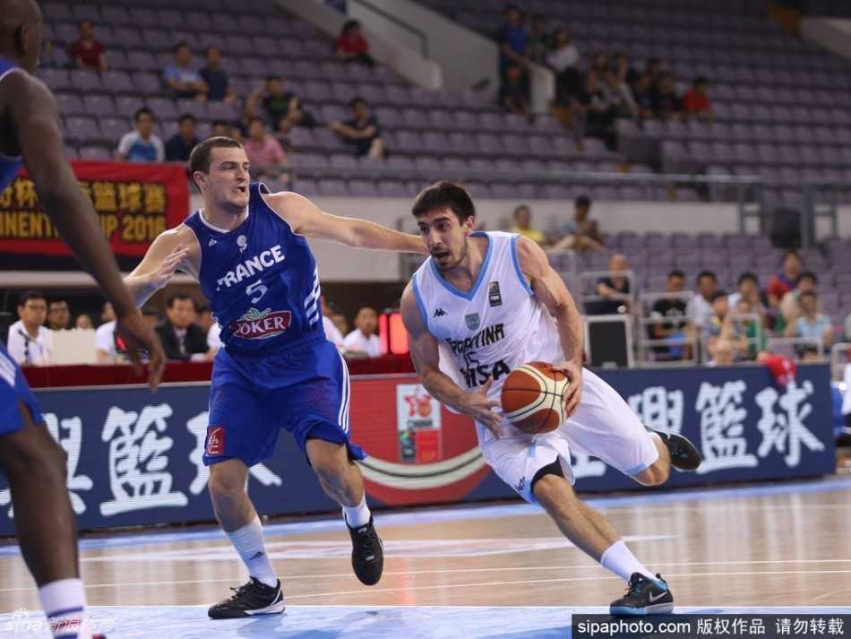 阿根廷队员在夹缝中寻找机会，他利用一个急停变向完成突破上篮，尽管身体失去平衡，依然奋力将球抛向篮筐。