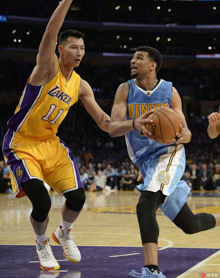 易建联在低位持球，面对防守者冷静地观察队友跑位，随时准备将球传给机会更好的队友。