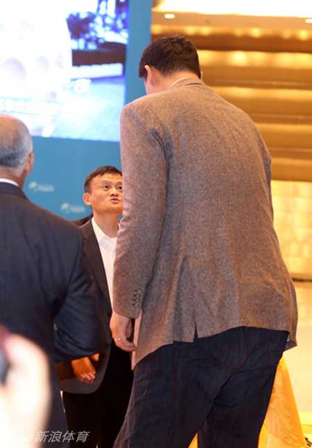 姚明微微弯腰俯身，将手伸向马云，巨大的身高差在这一刻显得既滑稽又充满尊重。