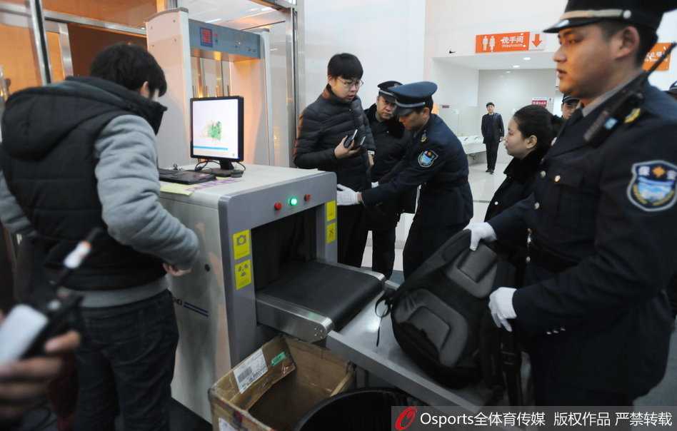 看台上的特勤安保人员背对赛场，目光如炬地扫视着狂热球迷的一举一动