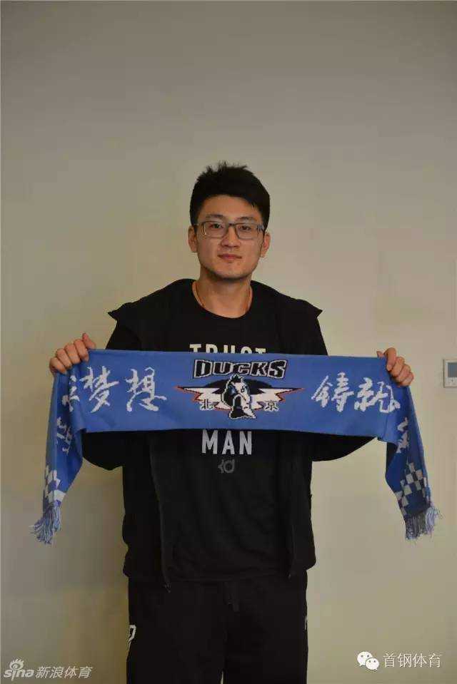 段江鹏小心翼翼地将北京男篮的围巾捧在手中，仔细端详，红色的围巾映衬着他眼里的期待，仿佛已经感受到京城球迷的呐喊。
