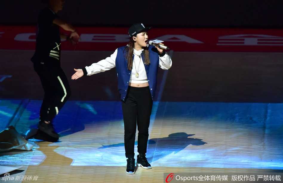 一位美艳的举牌女郎成为场边焦点，她手持下一节比赛提示牌，即便在短暂的休息时刻，也保持着专业的微笑和迷人的姿态