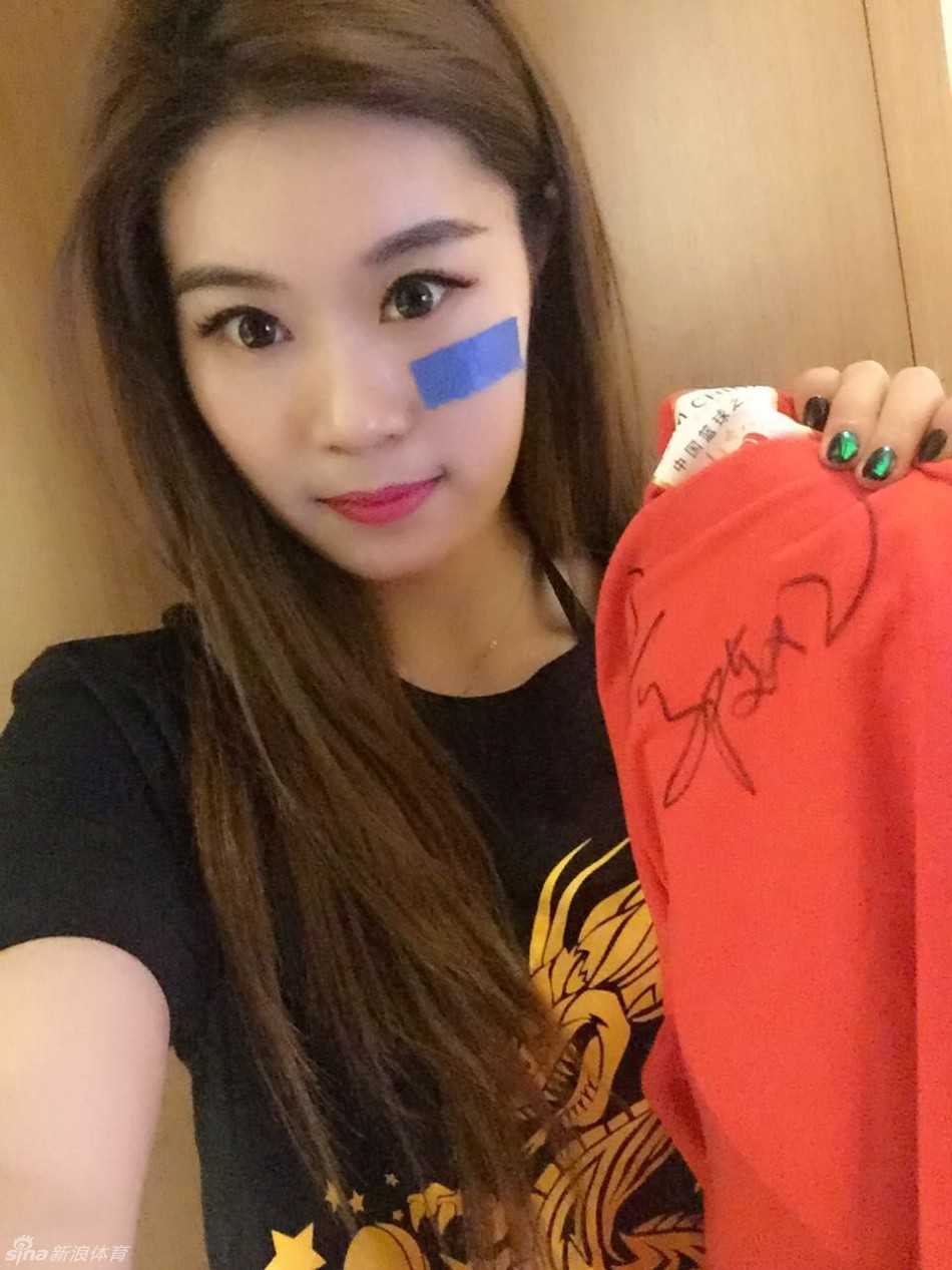 一群充满活力的啦啦队女孩在赛场边亲密合影，她们身着统一的队服，笑容灿烂，年轻的气息和团队的凝聚力扑面而来。