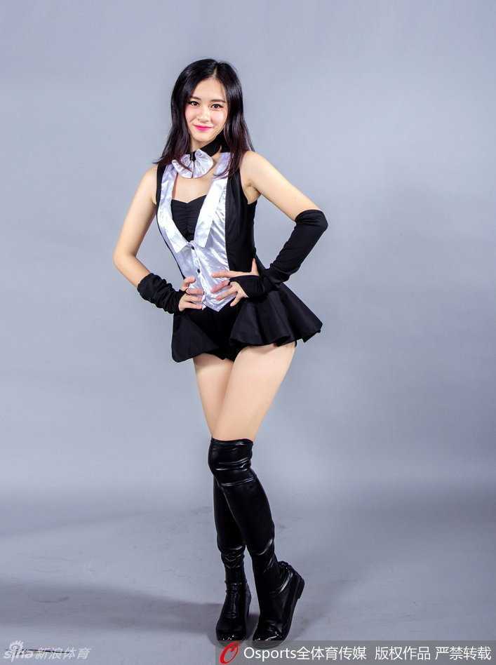 一位身穿黑白配色兔女郎服装的篮球宝贝，双手轻扶着头上的兔耳朵，对着镜头露出甜美的笑容，长长的卷发更添几分妩媚。