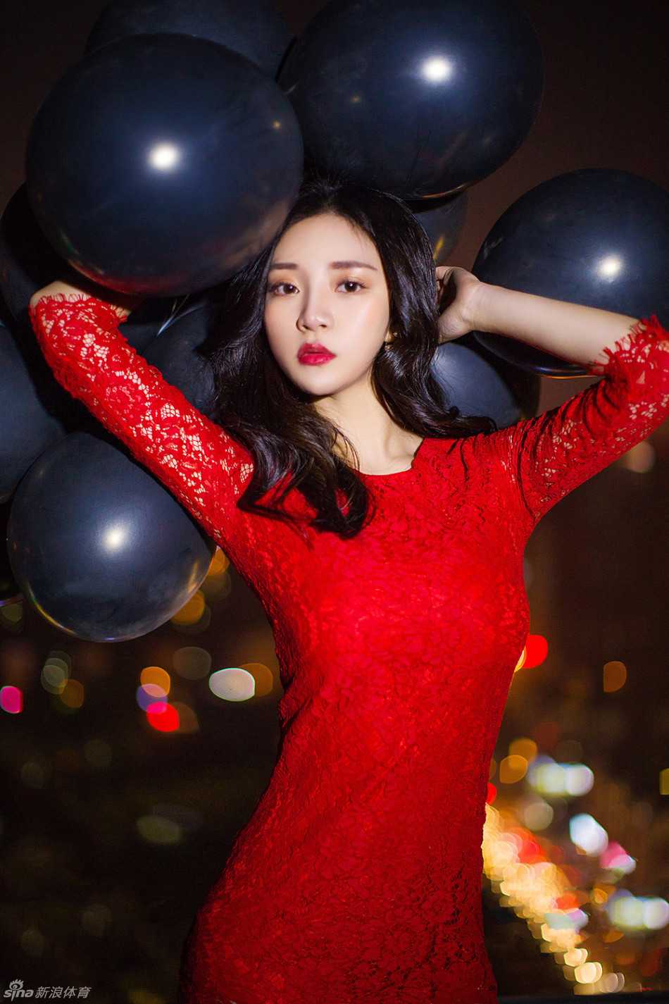 她侧身而立，一袭红裙勾勒出曼妙身姿，玉手轻托精致的下巴，眼神温柔地望向镜头，仿佛在与观者进行一场无声的对话。