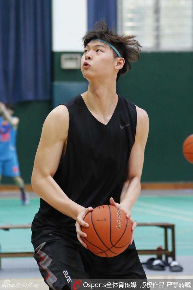 训练馆里王哲林与张德贵指导低头交流，教练手指战术板比划着跑位路线，大王认真倾听不时点头，身旁朱世龙和普拉达也在关注讨论。