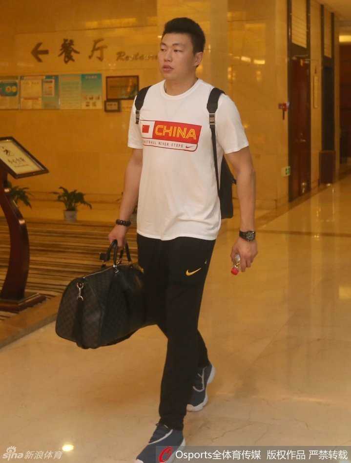 男篮队长周鹏背着双肩包从容登车，神情坚毅，肩扛着带队冲击奥运的重任。
