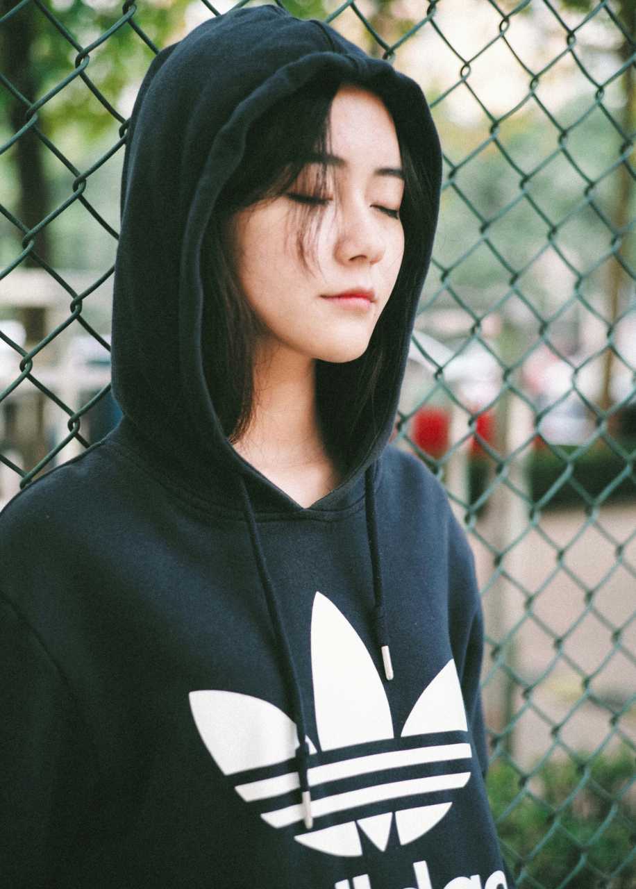 扎着马尾的篮球女孩在三分线外跳投，球衣随着动作飘起，脸上带着自信的笑容