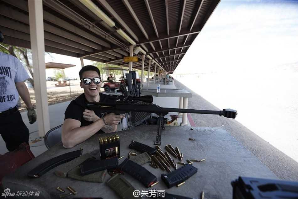 朱芳雨一身酷黑装扮，双手稳稳托举着友人那支极具威慑力的巴雷特狙击步枪，墨镜遮面，神情专注地望向远方，仿佛在寻找他的下一个“投篮点”。