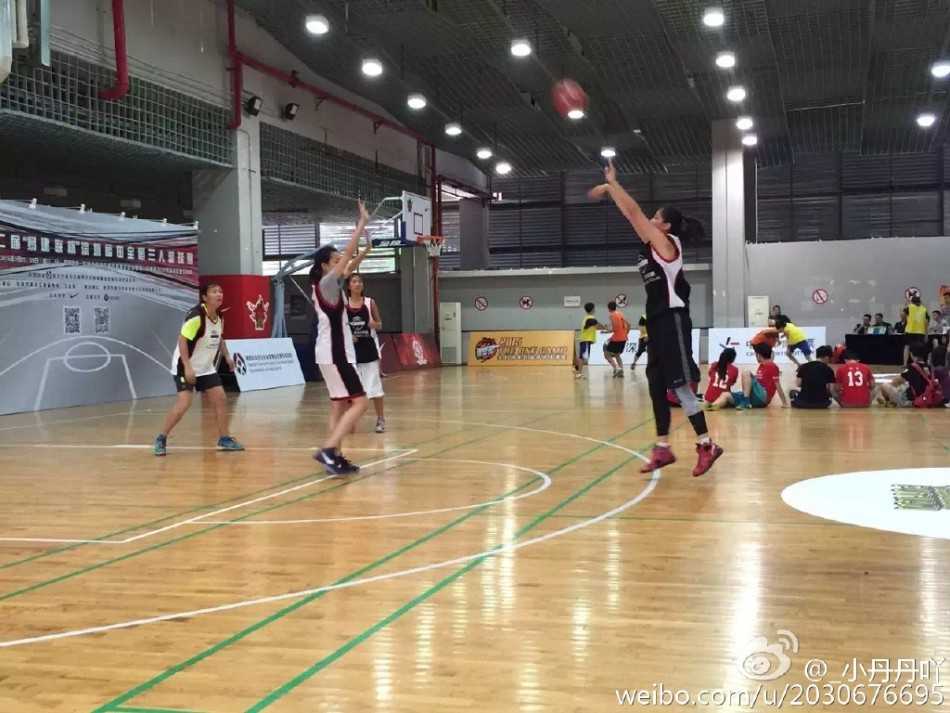 女裁判在比赛开始前认真整理着装，眼神中透露出对即将开始的比赛的专注与期待，充满了对篮球的热爱。