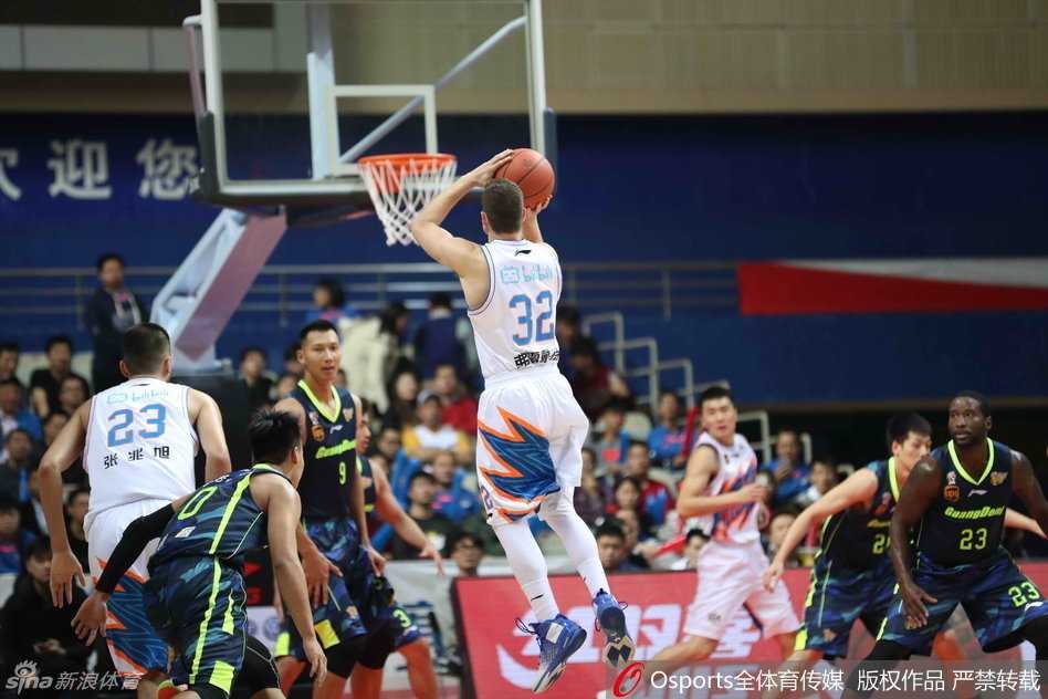 易建联面对严防死守强行持球突破，肌肉线条在灯光下分明，霸气尽显。