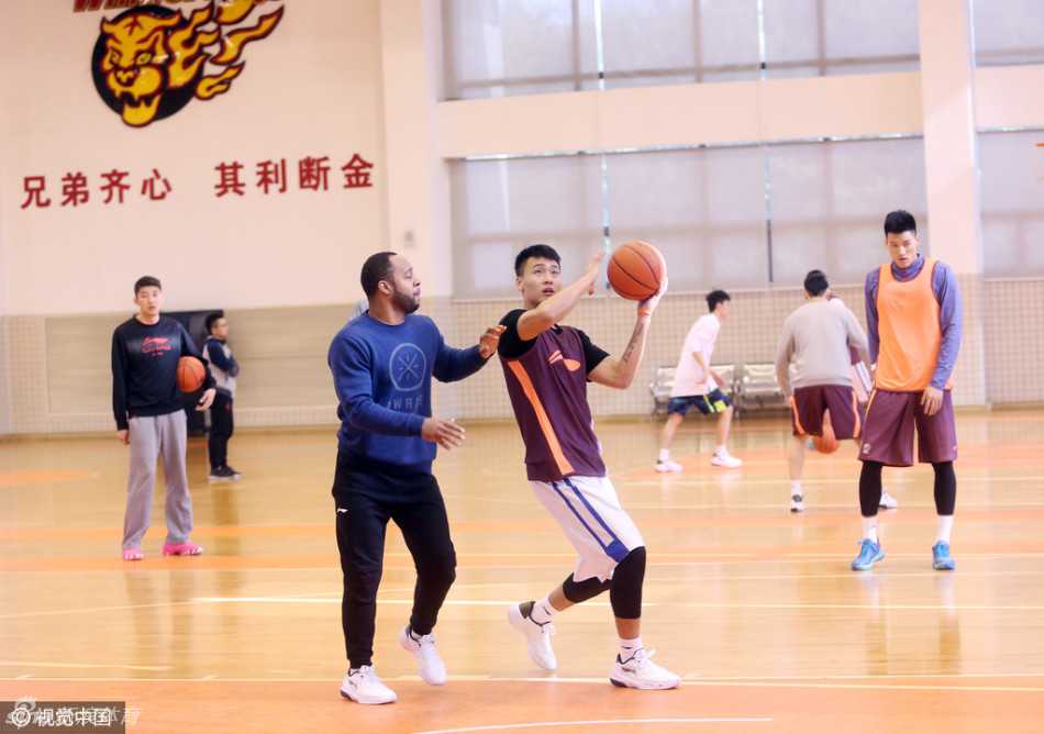 易建联转头望向另一片场地的队友，眼神中有关切也有期许，仿佛在用无声的语言告诉年轻队员：别慌，我们在一起战斗。