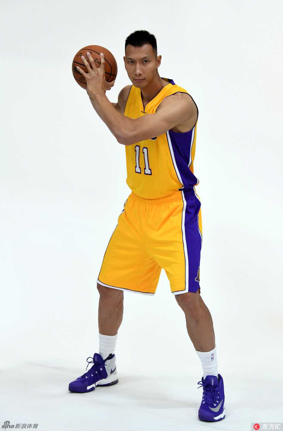 易建联侧身面对镜头，眼神深邃地望向远方，背景虚化的湖人队标仿佛是他职业生涯中一座需要再次征服的高峰。