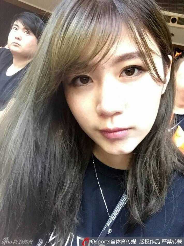 吴振瑜在海边享受阳光，她身穿白色露肩装，头戴草帽，回眸一笑，清新脱俗的气质与湛蓝的海景融为一体。