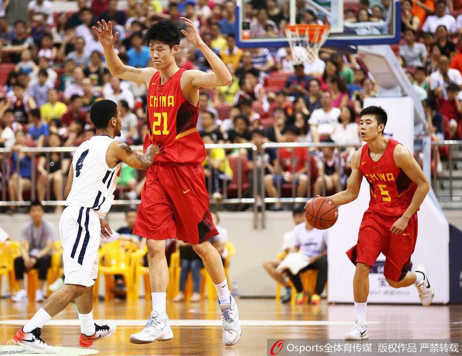 身高臂长的胡金秋在对方内线群中宛如一座高塔，他高高跃起，用指尖轻轻一点，将篮板球稳稳拨给队友，守护着国奥队的禁区领空。