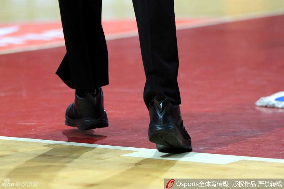 裁判双手交叉站在记录台前，低头的瞬间球鞋特写尤为突出，飞人logo仿佛在无声地质疑着联赛规则的执行尺度