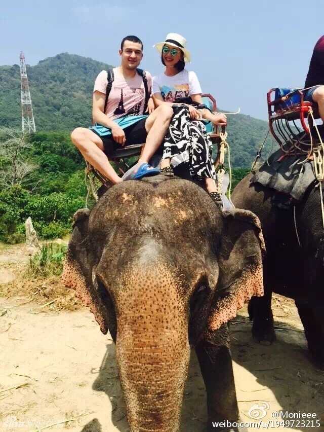 西热力江与爱妻甜蜜出游 骑大象吃海鲜羡煞旁人 西热力江换上帅气的印花衬衫,与爱妻在一处标志性景观前相拥合影,硬汉的温柔一面展露无遗。