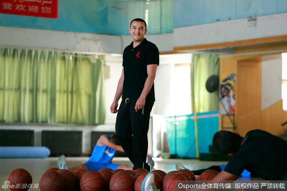 西热力江的夏日播种 篮球训练营里指点江山 外籍教练在一旁辅助教学,西热力江双手抱胸,神情专注而严肃,仔细观察着场上的训练环节