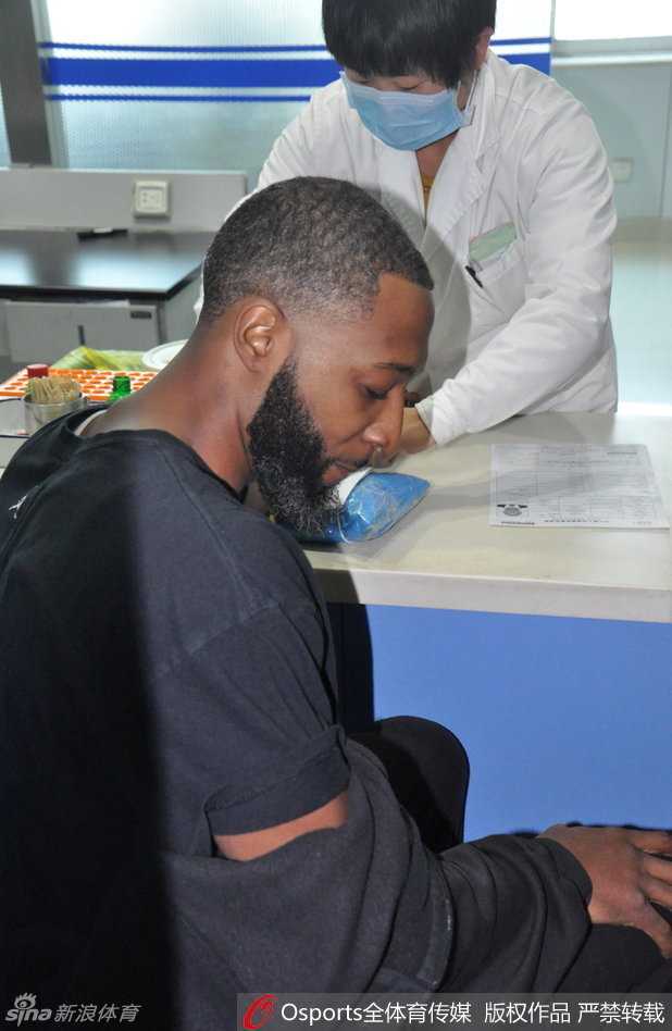 抽血间隙，普莱斯侧身面对镜头，标志性的浓密胡须下露出一抹淡定的微笑，仿佛在丈量着与胜利之间的距离。