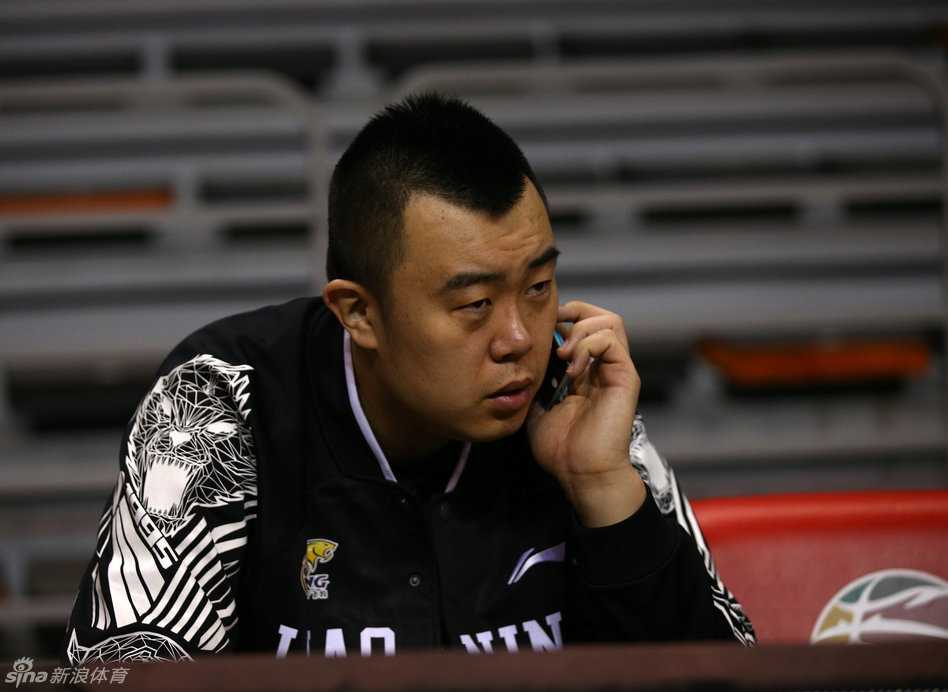 辽宁男篮光影瞬间:那些笑容与汗水交织的争冠岁月 主教练郭士强在场边接受媒体采访,表情认真严肃,拿着战术板的手势显示出他对球队战术细节的严格把控