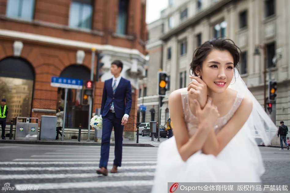 辽宁迎亲日,金陵结缘时:同曦射手马壮与女排自由人张薇的跨项爱情长跑 新娘张薇一袭简洁的缎面婚纱,手持简约手捧花,独自立于落地窗前,阳光勾勒出她优美的身形曲线,面容恬静而充满对未来的憧憬。