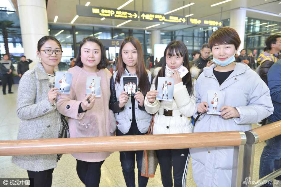 辽篮众将抵沈球迷热情接机 签名合影温情满溢 一位女球迷在人群中高高举起手中的赵继伟海报,脸上满是终于见到偶像的兴奋与满足,眼神中闪烁着光芒。