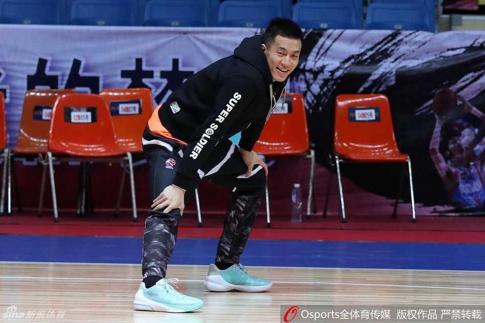 主教练郭士强神情专注地注视着训练场，他双手抱胸陷入沉思，并与身边的助理教练低声探讨着战术细节，神情严肃而投入。