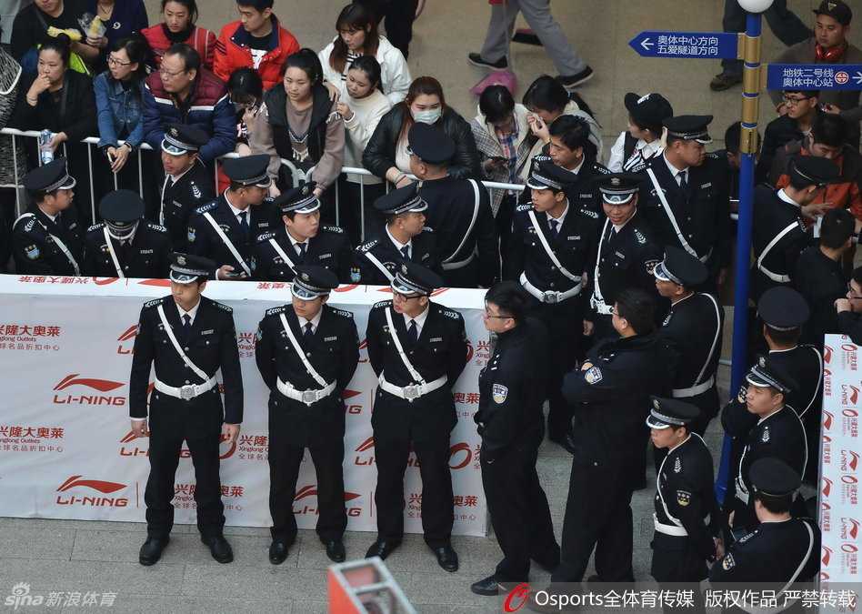 杨鸣被一位热情的女球迷拉住请求合影，表情带着一丝无奈与腼腆