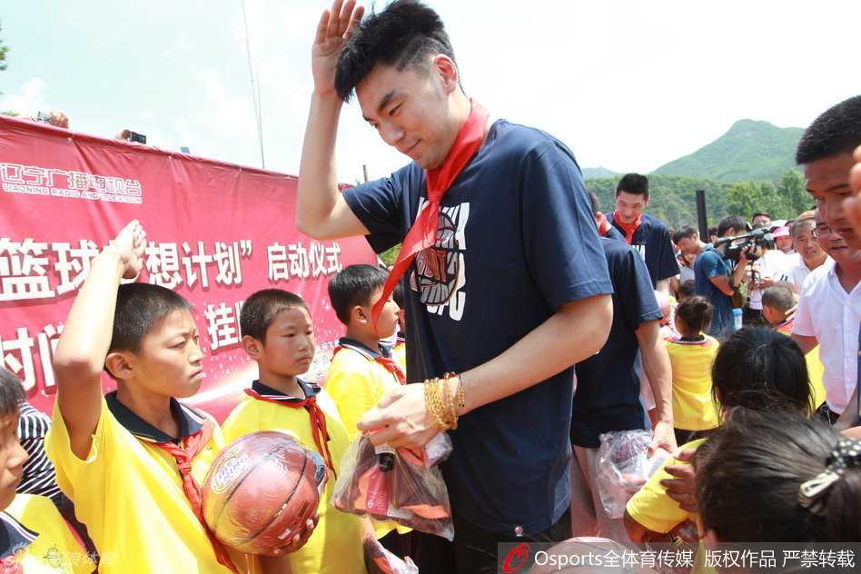 辽篮将士情暖岫岩山村小学 篮球梦想在山沟沟里萌芽 李晓旭面带微笑,单膝点地俯身为身前的小球迷在篮球上签名,周围的小朋友用崇拜的眼神紧紧盯着他的一举一动。