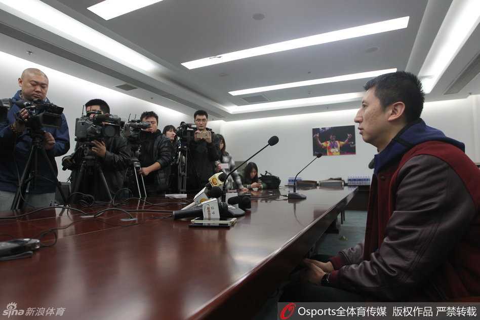 场边的郭士强手拿战术板，神情专注地望向球场，眼神中透露出对胜利的渴望和对场上局势的精准判断。