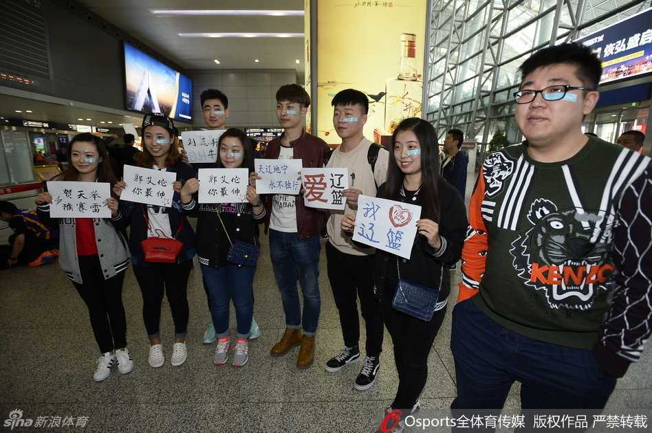 聚集在机场的辽宁球迷们高举着手机和标语，眼神中充满了期盼，站在最前面的几位球迷脸上贴着创可贴，他们的身影构成了当天最温暖的画面。