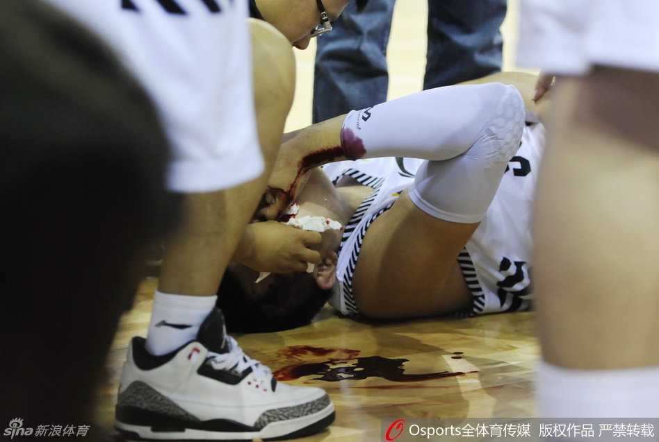 辽宁男篮的队医神情严肃地蹲在地上，手持医用纱布和止血用具，小心翼翼地处理韩德君血流不止的鼻部伤口，场边的担架已经准备就绪。