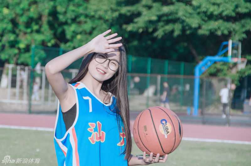 镜头内外皆风景 汕大晴子任丹妮的篮球青春 任丹妮轻撩起被风吹乱的秀发,背景是汕头大学的篮球架与黄昏的柔光,整个画面充满了动态的青春美感。