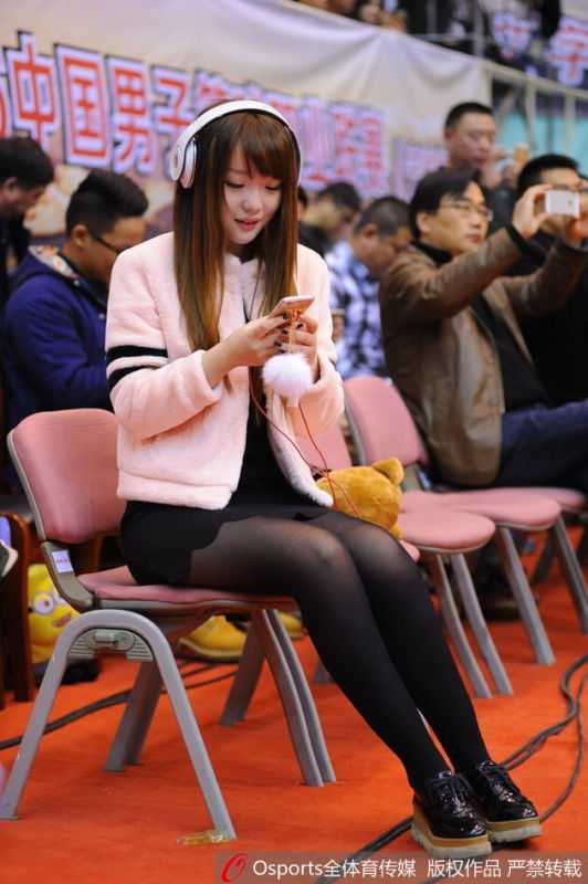 雅戈尔体育馆的铁军红颜:一位八一女球迷和她的专属座位 比赛结束后,女球迷开心地与几位身穿八一队服的球员站在一起合影留念,她手中可能拿着签名球衣,笑容灿烂。