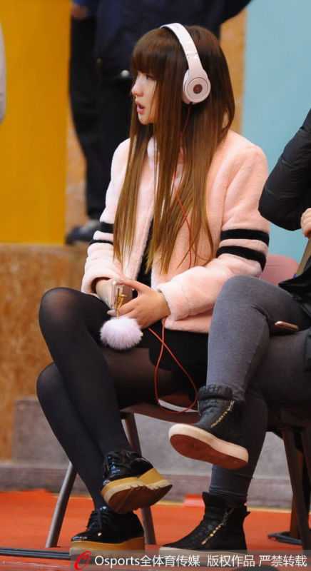 雅戈尔体育馆的铁军红颜:一位八一女球迷和她的专属座位 在空旷的雅戈尔体育馆内,女球迷独自坐在她固定的座位上,目光柔和地望向球场,仿佛在回味往昔的精彩瞬间。