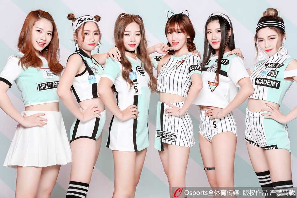 写真中的队员们排成一列，俏皮地歪着头，手中花球高高抛起，仿佛将赛场上的紧张气氛瞬间融化在这片粉色的欢乐海洋里。