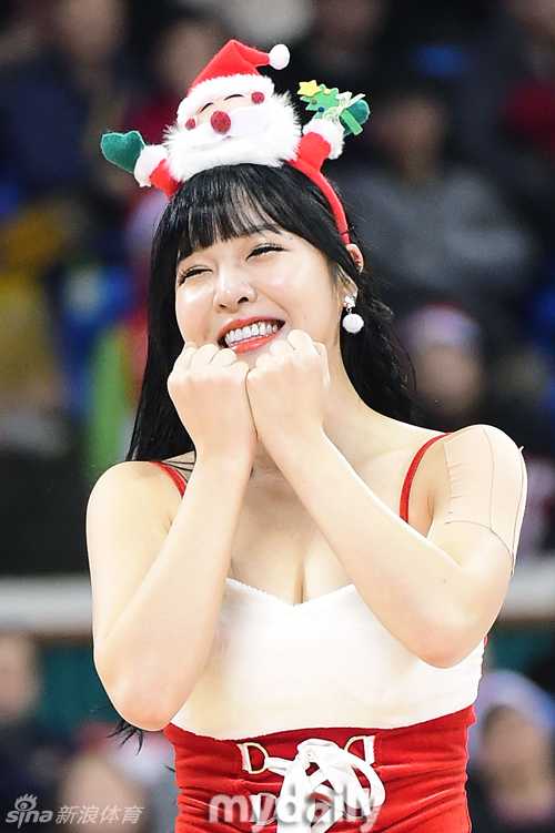 镜头捕捉到两位啦啦队员背靠背舞蹈的瞬间，她们头戴红色蝴蝶结，白色长靴衬托出修长美腿，宛如从童话中走出的玩偶。