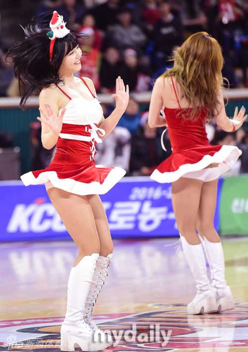 一名队员正在弯腰调整装饰袜，这一不经意的瞬间被镜头记录，反而流露出一种自然可爱的亲和力，背景是模糊的观众席。