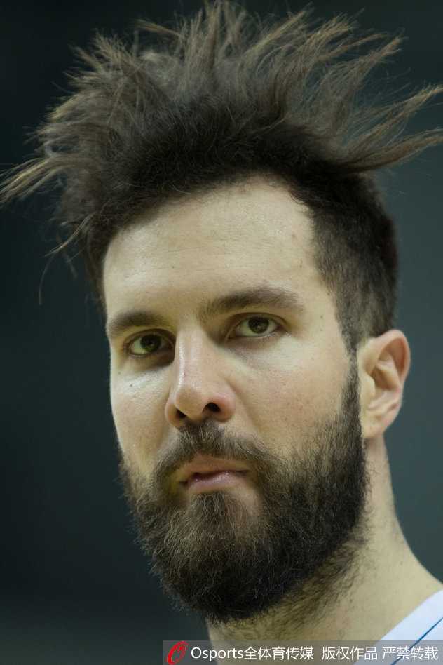 一位球员在激烈对抗中失去重心，身体倾斜45度却依然将球艰难传出，身后的队友则一脸惊讶地张开双手准备接应。