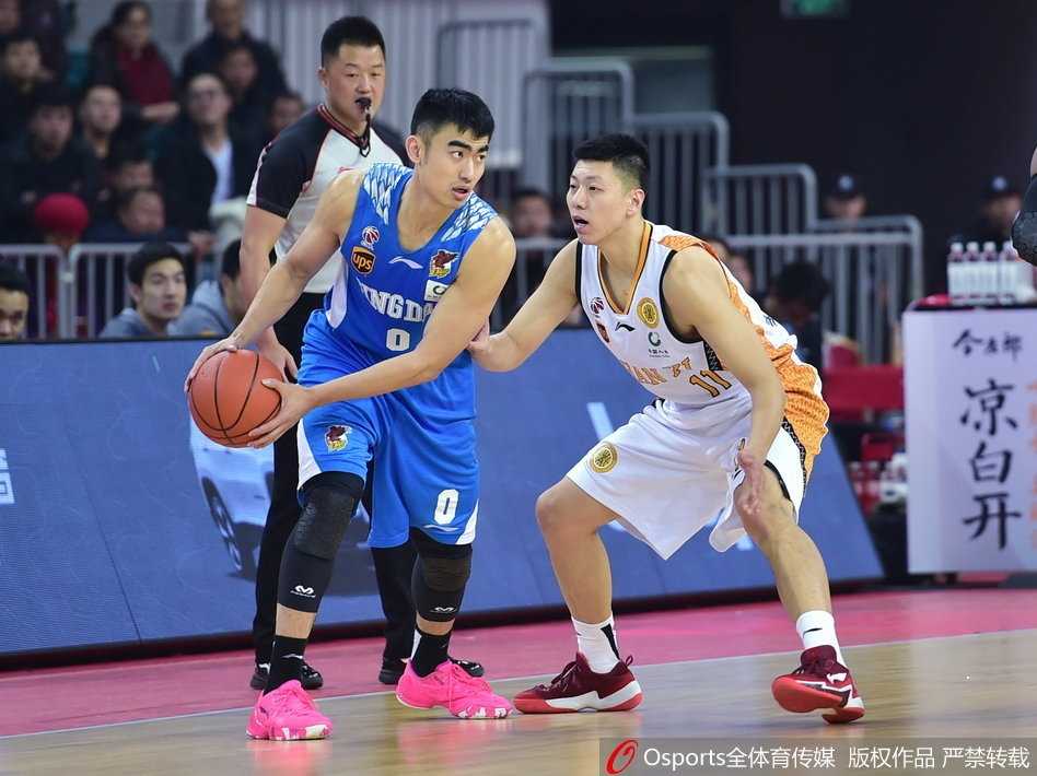CBA焦点战:山西汾酒主场击退青岛,斯科拉吉布森上演飙分大战 山西队核心曾令旭运球过半场,他冷静地观察着场上局势,举手示意队友跑位,青岛队的防守球员寸步不离紧紧跟随。