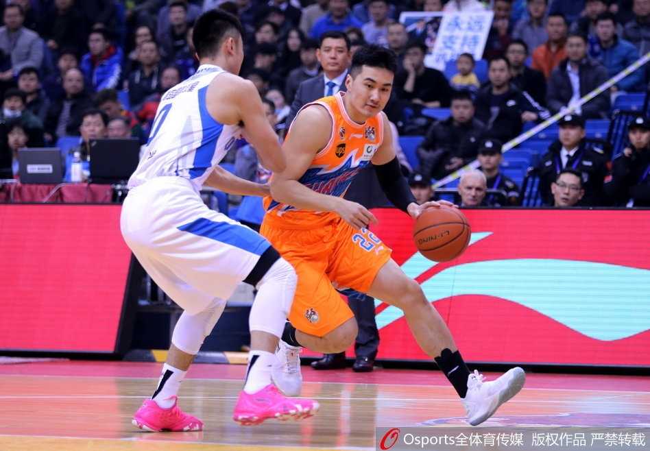 青岛队外援吉布森在两人包夹下强行突破，眼神坚毅，如闪电般撕开上海队防线