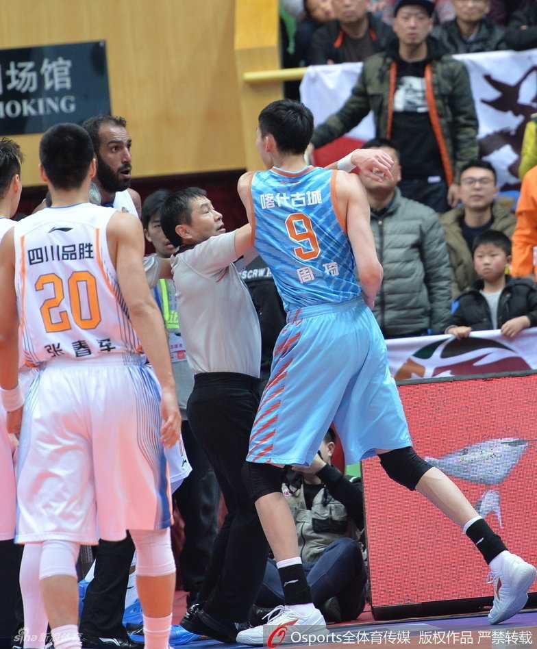 CBA赛场火爆一幕:周琦遭锁喉怒挥拳引发冲突 裁判奋力张开双臂,将怒火中烧的周琦与哈达迪隔开,竭力控制混乱的场面。