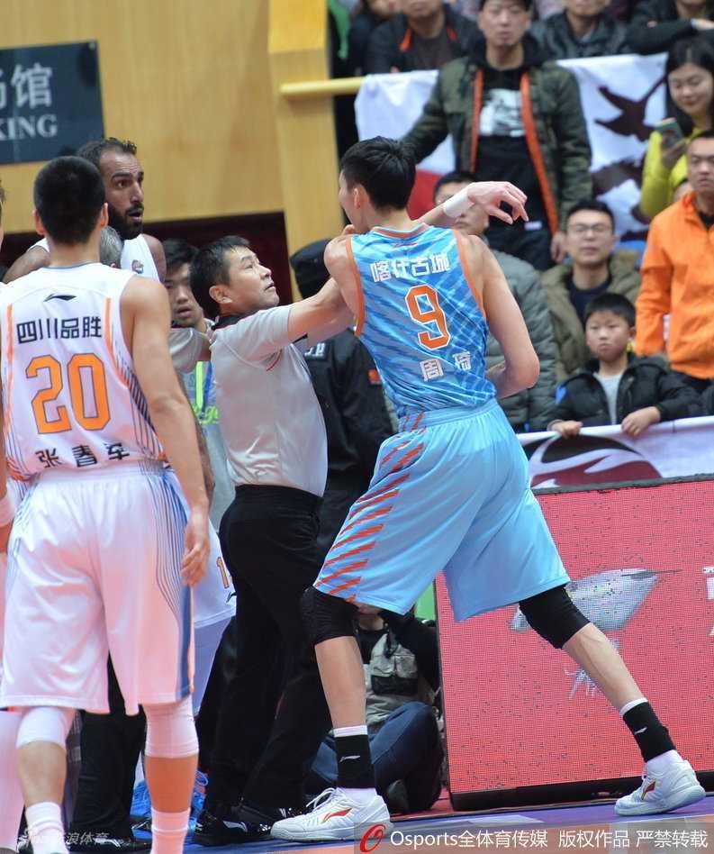 CBA赛场火爆一幕:周琦遭锁喉怒挥拳引发冲突 新疆队主帅李秋平冲进球场,双手紧紧抱住周琦的腰,防止他再次冲向对手。