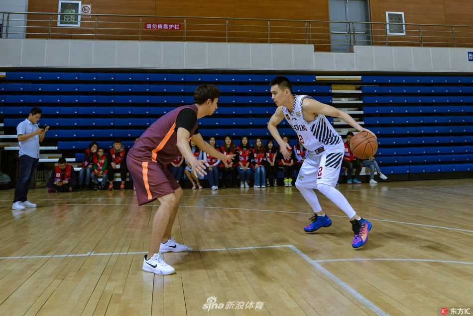 杨鸣在人群中专注地为球迷签名，身旁的手机和目光记录着这追星的一刻，他身着白衣的身影成为现场最亮丽的风景线。