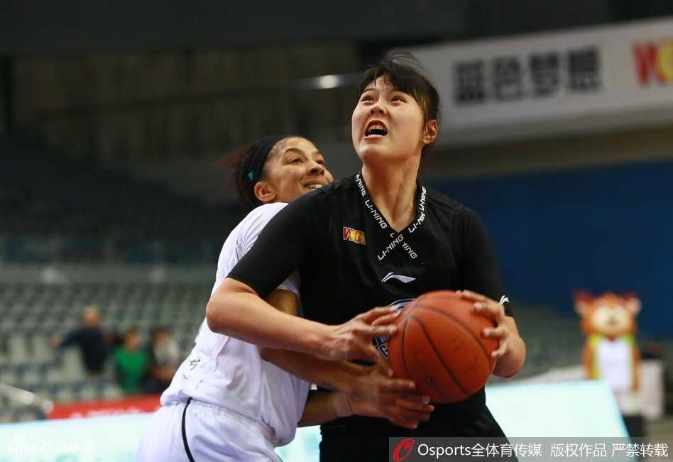 广东队球员沈怡面对贴身紧防，冷静地寻找传球路线，她灵动的身影与新疆队员的严密防守形成鲜明对比，仿佛在刀尖上跳舞。