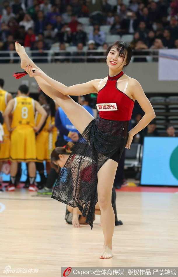 浙江蕞红啦啦队的队员们身着一袭飘逸红纱裙，赤足站立在冰冷的赛场木地板上，她们手持折扇轻舞飞扬，眼神中透露出江南女子的温婉与坚定，仿佛将观众从激烈的篮球战场带入了水墨画中的江南水乡。