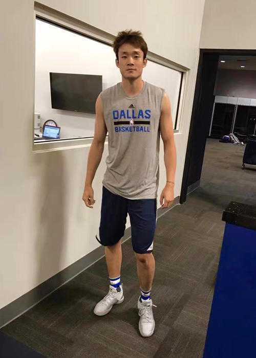 丁彦雨航在助理教练的指导下进行力量训练，腿部肌肉暴起青筋，汗水顺着脸颊滴落，眼神中透露出不屈的斗志