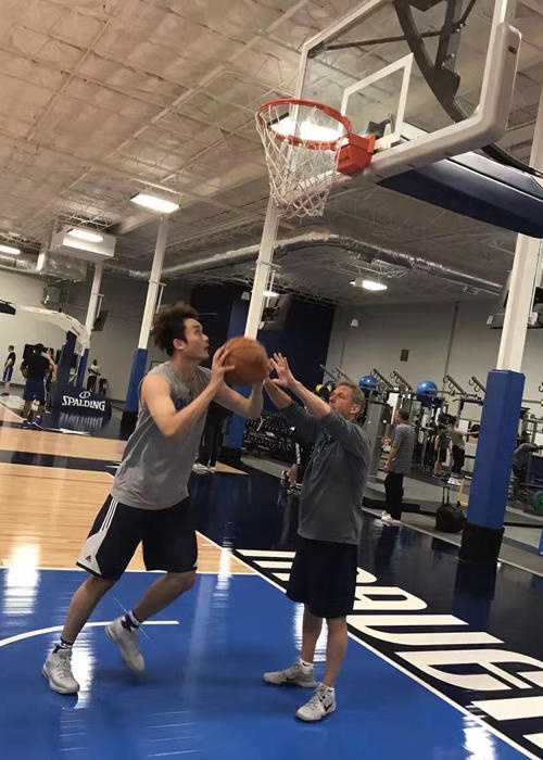 训练间隙，丁彦雨航与教练组成员交流，他一边擦汗一边认真聆听，脖子上挂着白色毛巾，显得谦逊而专注