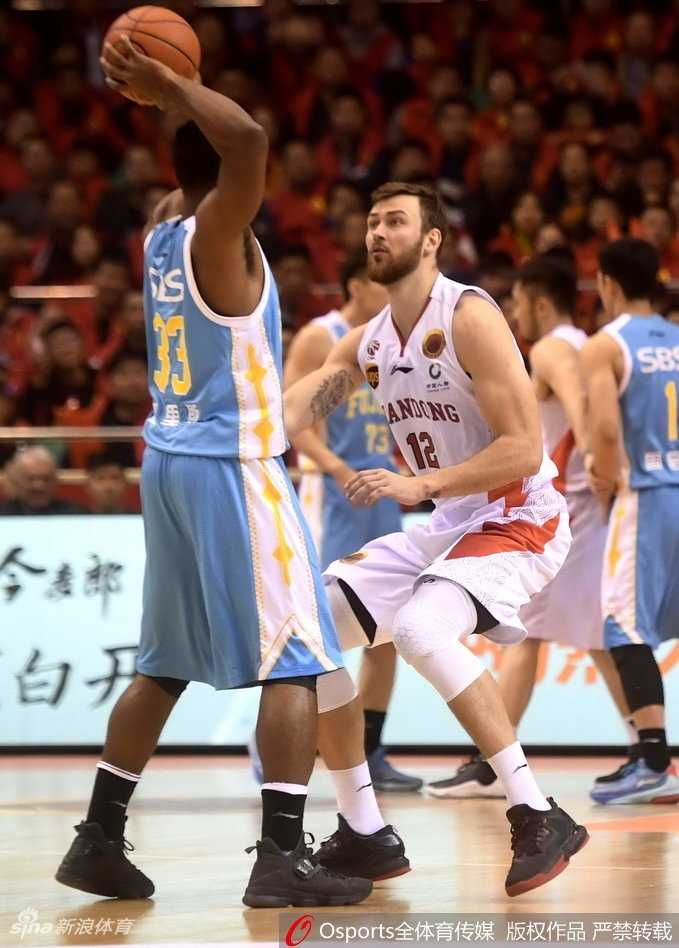 取胜后的山东男篮士气高涨，球员们围成一圈肩膀相靠，怒吼着庆祝这场来之不易的胜利，团队力量在这一刻熠熠生辉。